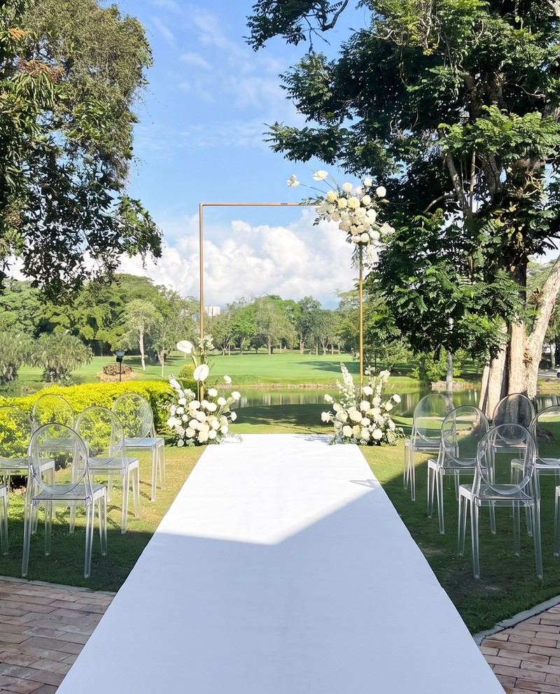 El mismo campo con arco cuadrado blanco y sillas transparentes